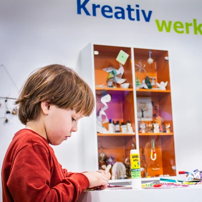 Junge bastelt in der Kreativwerkstatt.